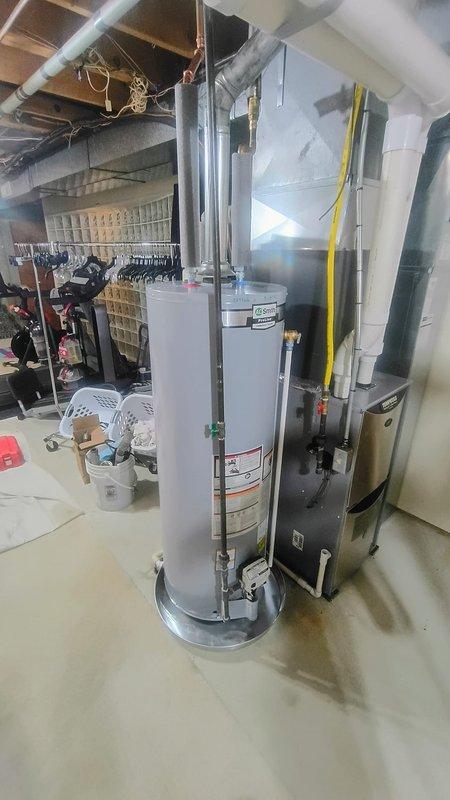 Installed AO Smith natural draft 40-gallon water heater in basement mechanical room with drain pan and expansion tank. Replaced quarter turn valve above unit and gate valve on water supply line to ensure proper shutoff capability and system protection.