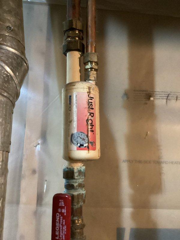 Responded to water heater leak in basement with visible moisture spotting on floor. Upon inspection, identified active leak originating from A.O. Smith ProLine water heater plumbing connections. Examined copper piping, brass compression fittings, and associated components including pressure relief valve and expansion tank. Documented existing plumbing configuration with water treatment system and assessed condition of connections showing mineral deposits and corrosion consistent with prolonged leak activity. Reviewed membership benefits and available service options with property owner for necessary repairs to resolve ongoing water heater leak issue.
