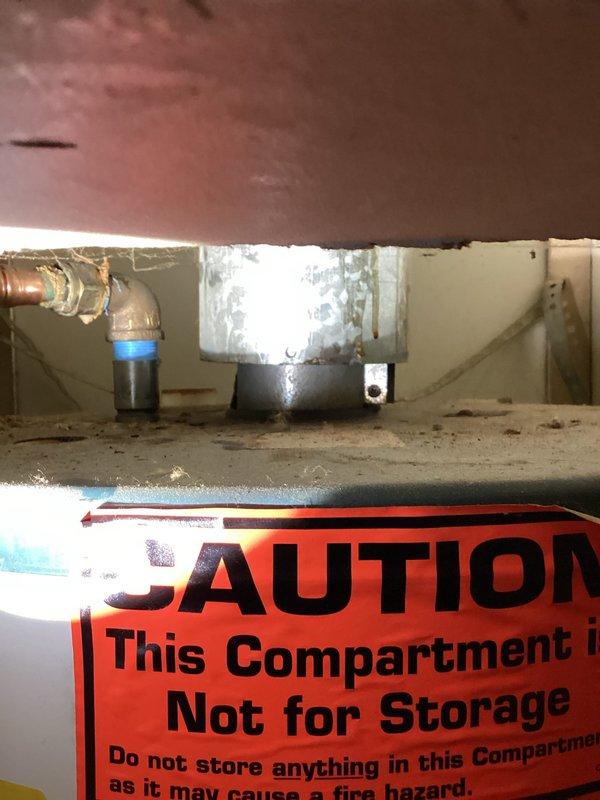 Responded to service call for 40-gallon gas water heater in mobile home that would not ignite. Performed on-site inspection of tanked water heater installation, examining gas control valve assembly, pilot light system, and gas supply connections. Documented existing installation conditions including flexible gas connector, control valve with red knobs, and venting configuration. Assessed unit for potential repair versus replacement options and photographed equipment including gas valve assembly, plumbing connections, and warning labels in utility closet compartment. Provided technical evaluation and recommendations to customer regarding water heater serviceability.