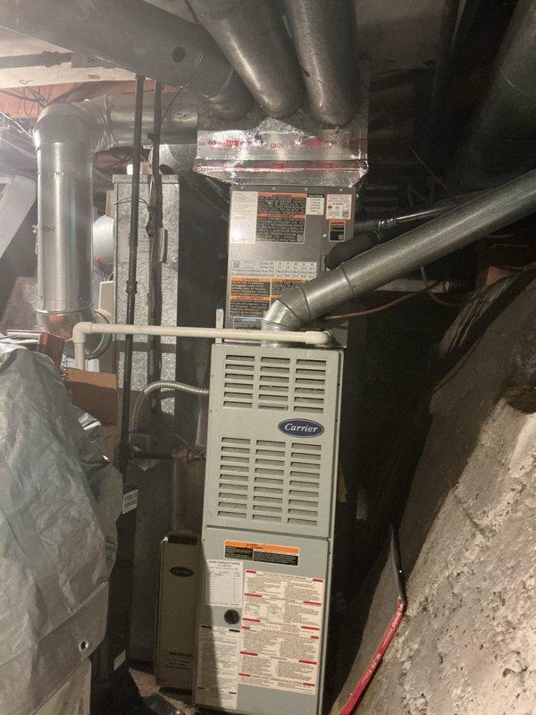 Completed installation of Lennox ML13 air conditioning system with T4 thermostat in residential basement location. Connected new outdoor condensing unit to existing Carrier furnace air handler, integrated refrigerant lines and condensate drainage, verified proper electrical connections, and programmed thermostat for optimal cooling performance. System tested and operational, balance payment collected from customer.