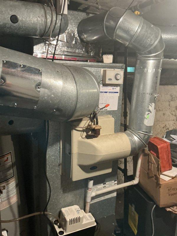 Completed installation of Lennox ML13 air conditioning system with T4 thermostat in residential basement location. Connected new outdoor condensing unit to existing Carrier furnace air handler, integrated refrigerant lines and condensate drainage, verified proper electrical connections, and programmed thermostat for optimal cooling performance. System tested and operational, balance payment collected from customer.