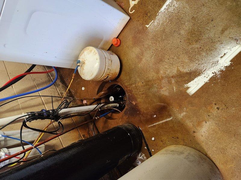 # Sump Pump System Evaluation and Service

Responded to ongoing basement flooding issue in 76-year-old residential property where sump pump system was failing to maintain water levels after several days of standing water accumulation. Upon arrival, performed comprehensive assessment of existing sump pump installation and discharge piping configuration.

Inspected primary sump pump assembly, basin, and associated plumbing components including PVC discharge lines and check valve operation. Evaluated pump motor performance, float switch functionality, and electrical connections. Examined copper and PVC piping infrastructure for proper drainage capacity and potential restrictions or blockages affecting system performance.

Documented existing conditions through photographic evidence showing pump basin setup, discharge piping arrangement with P-trap configuration, and overall mechanical space layout. Assessed adequacy of current pump capacity relative to water intrusion rate and basin size 