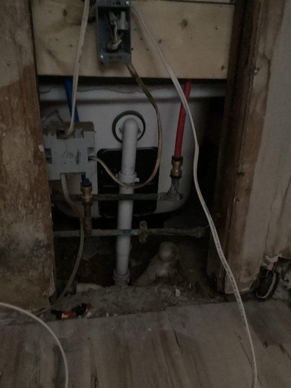 Responded to vacant rental property for water leak assessment under slab foundation. Confirmed water supply was shut off with no standing water present. Inspected water heater connections and exposed plumbing infrastructure, documenting copper pipe conditions, PVC routing, and valve configurations. Evaluated existing plumbing layout including wall-mounted water heater with visible control panel, brass fittings, and distribution lines. Photographed plumbing system within wall cavity showing white control unit, PVC piping, flexible tubing connections, and wooden framing structure. Provided findings via phone and email per property owner's request, including documentation of current system conditions and recommendations for re-routing options to bypass under-slab leak location as preferred repair method.