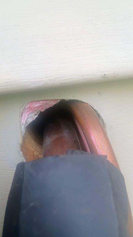 Responded to service call regarding unsealed penetration around refrigerant lines and loud noise from outdoor unit during startup and shutdown. Inspected interior wall penetration where copper refrigerant lines enter building and confirmed opening was not properly sealed, allowing potential air infiltration and energy loss. Documented condition with photos showing exposed cavity around copper tubing. Examined exterior refrigerant line set and observed black foam pipe insulation on copper lines at exterior wall, with exposed copper visible at top section. Evaluated outdoor condensing unit operation and documented reported thunk noise during compressor cycling, which may indicate refrigerant pressure equalization or potential mechanical issue requiring further diagnosis.