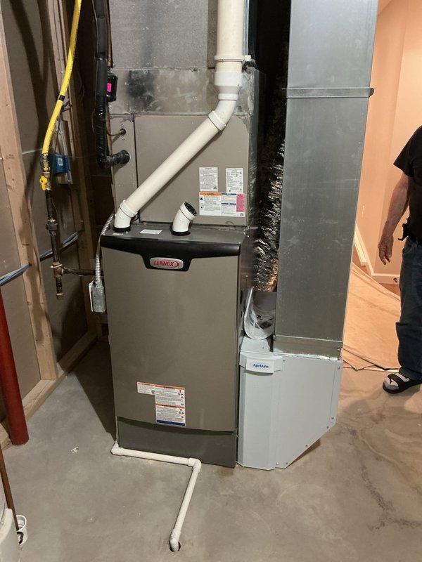 Installed Lennox EL297UH090XV48CK high-efficiency furnace with Aprilaire 1620 media air cleaner in basement location. Reused existing thermostat and verified proper system operation with temperature readings confirming adequate heating output.