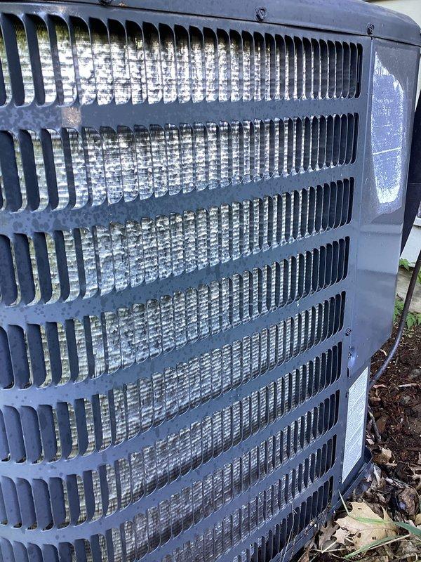 Responded to no cooling complaint on 10-year-old residential air conditioning system. Upon arrival, confirmed outdoor unit was running but not providing adequate cooling to home. Performed visual inspection of outdoor condenser unit, noting weathered exterior condition with debris accumulation at base and aged coil fins showing environmental exposure. Documented equipment condition with photographs of exterior cabinet and condenser coil assembly. Unit displayed signs of age-related wear consistent with decade of operation, including discoloration of coil fins and accumulation of organic debris around base. Assessed overall system operation and component condition to determine cause of cooling failure and provide recommendations for repair or replacement options given age of equipment.