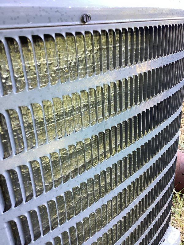 Responded to no cooling complaint on 10-year-old residential air conditioning system. Upon arrival, confirmed outdoor unit was running but not providing adequate cooling to home. Performed visual inspection of outdoor condenser unit, noting weathered exterior condition with debris accumulation at base and aged coil fins showing environmental exposure. Documented equipment condition with photographs of exterior cabinet and condenser coil assembly. Unit displayed signs of age-related wear consistent with decade of operation, including discoloration of coil fins and accumulation of organic debris around base. Assessed overall system operation and component condition to determine cause of cooling failure and provide recommendations for repair or replacement options given age of equipment.