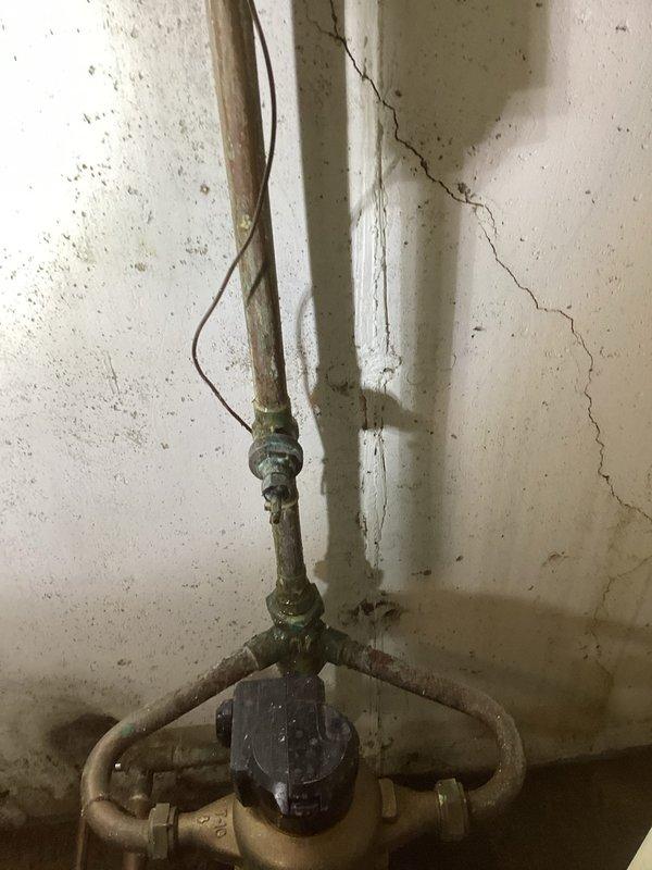 Responded to a water leak at an irrigation fixture in the basement. Upon arrival, found active leaking around copper piping connections serving the irrigation system. The existing plumbing assembly showed significant age-related deterioration, including corrosion, mineral deposits, and oxidation on copper pipes and brass fittings.

Inspected the affected area and identified the leak source at a compromised connection point near a shutoff valve. The surrounding wall exhibited water damage, cracking, and discoloration consistent with prolonged moisture exposure. Shut off water supply to the irrigation system to prevent further water intrusion.

Disassembled the faulty connection and assessed the condition of the copper piping and fittings. Cleaned oxidized surfaces and removed corroded components. Replaced worn brass fittings and compromised sections of copper pipe as needed. Reinstalled a secure, watertight connection using proper soldering techniques and new compression fittings where 