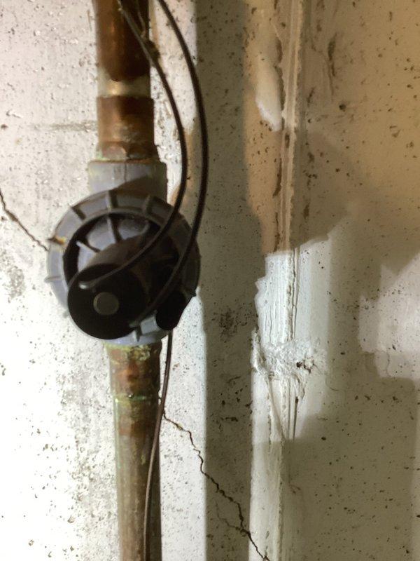 Responded to a water leak at an irrigation fixture in the basement. Upon arrival, found active leaking around copper piping connections serving the irrigation system. The existing plumbing assembly showed significant age-related deterioration, including corrosion, mineral deposits, and oxidation on copper pipes and brass fittings.

Inspected the affected area and identified the leak source at a compromised connection point near a shutoff valve. The surrounding wall exhibited water damage, cracking, and discoloration consistent with prolonged moisture exposure. Shut off water supply to the irrigation system to prevent further water intrusion.

Disassembled the faulty connection and assessed the condition of the copper piping and fittings. Cleaned oxidized surfaces and removed corroded components. Replaced worn brass fittings and compromised sections of copper pipe as needed. Reinstalled a secure, watertight connection using proper soldering techniques and new compression fittings where 