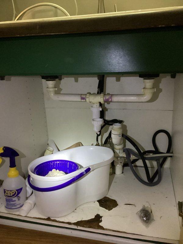 Responded to kitchen sink clog with water leaking onto floor. Customer had previously attempted to clear drain with foam cleaner four days prior without success. Upon inspection, accessed cabinet beneath sink and identified blockage in drain line. Utilized mechanical drain clearing equipment to remove obstruction from P-trap and drain assembly. Cleared accumulated debris causing backup and leak. Tested drainage flow and verified proper function of all connections. Cleaned work area and confirmed no additional leaks present. Kitchen sink now draining properly with no water escaping onto cabinet floor.