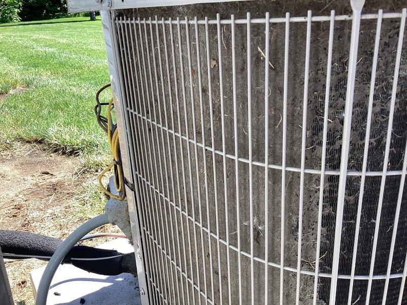 Completed comprehensive cooling season tune-up on 9-year-old residential air conditioning system. Performed visual inspection of outdoor condenser unit, noting significant accumulation of dirt, dust, and debris on condenser coils and protective wire guard. Opened electrical control panel and inspected internal components including dual-run capacitor, contactor relay, and associated wiring connections for proper operation and signs of wear. Cleaned condenser coils and removed organic debris from unit exterior to restore optimal airflow and heat transfer efficiency. Verified system operational status and confirmed unit cycling properly with no performance issues reported by customer.