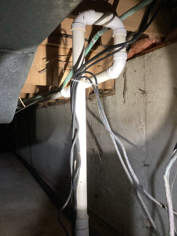 Responded to service call for non-functioning primary sump pump in 50-year-old residential property. Upon arrival, found main sump pump inoperative with backup Watchdog unit actively running and emitting audible alarm indicating primary system failure. Inspection revealed corroded copper piping components and significant mineral deposits in sump basin with discolored water present. Assessed vertical PVC discharge piping configuration and electrical connections in basement utility area. Documented existing conditions including aged pump mechanism, rust deterioration on metallic components, and overall system wear consistent with home age. Backup pump confirmed operational but requiring primary system restoration to prevent overwork and potential secondary failure.