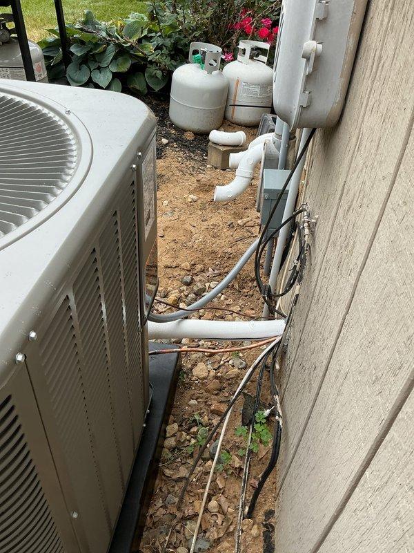 Completed full HVAC system installation including new outdoor condensing unit mounted on concrete pad with proper leveling. Installed first-time PVC venting system with appropriate elbows and routing along building exterior, new electrical disconnect box, whip connection, and refrigerant line set with proper insulation. All components tested and verified operational with digital instrumentation to ensure proper system performance.