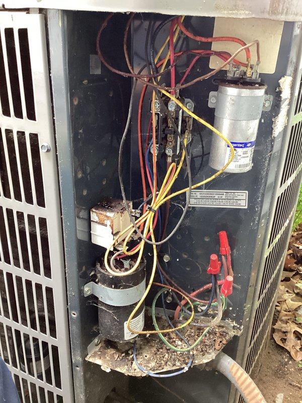 # HVAC Maintenance Service Completed

Performed scheduled preventive maintenance on commercial HVAC cooling unit. Upon inspection, discovered significant environmental contamination and component deterioration throughout the system. Internal compartment showed extensive dirt, debris, and leaf matter accumulation, with visible corrosion on electrical connections and mounting hardware. Capacitor and associated wiring connections exhibited oxidation and exposure damage. Documented current condition of unit showing compromised electrical components, corroded white rectangular relay or contactor with heavy rust buildup, and deteriorated interior surfaces. System requires comprehensive cleaning and component replacement to restore proper operation and prevent potential electrical failures.