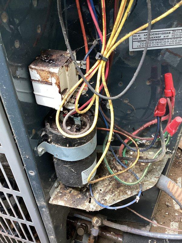 # HVAC Maintenance Service Completed

Performed scheduled preventive maintenance on commercial HVAC cooling unit. Upon inspection, discovered significant environmental contamination and component deterioration throughout the system. Internal compartment showed extensive dirt, debris, and leaf matter accumulation, with visible corrosion on electrical connections and mounting hardware. Capacitor and associated wiring connections exhibited oxidation and exposure damage. Documented current condition of unit showing compromised electrical components, corroded white rectangular relay or contactor with heavy rust buildup, and deteriorated interior surfaces. System requires comprehensive cleaning and component replacement to restore proper operation and prevent potential electrical failures.