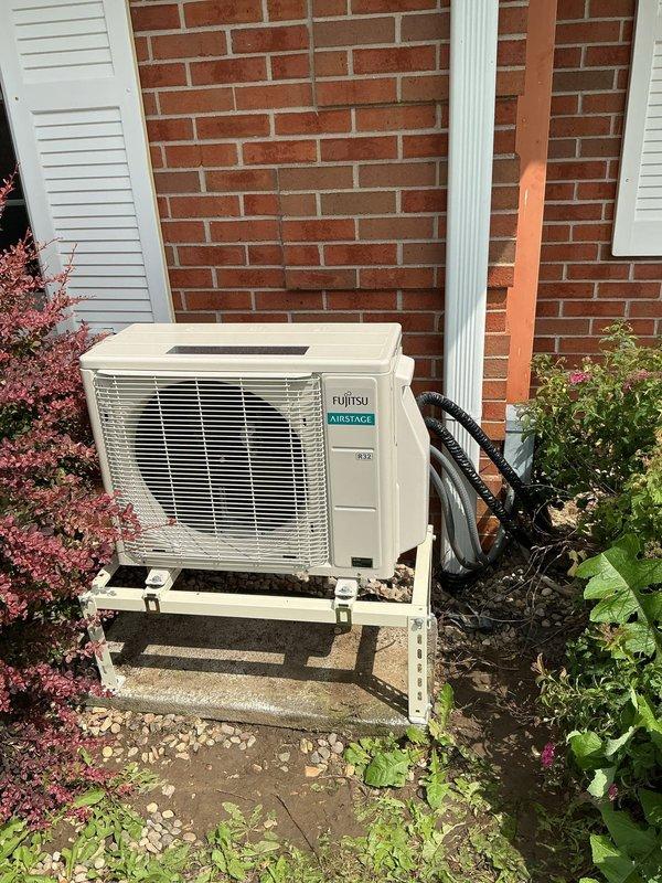 Completed installation of Fujitsu Airstage mini-split heat pump system at residential property. Mounted AOLH12KNAS1 outdoor condensing unit on metal bracket against brick exterior wall with proper elevation and drainage clearance. Installed ASLH12KNAS indoor air handler unit. Replaced existing line set with new refrigerant lines, properly insulated and routed along exterior wall. Established refrigerant connections between indoor and outdoor units. Evacuated system using vacuum pump to remove moisture and non-condensables from refrigerant lines. Charged system with appropriate refrigerant type and quantity per manufacturer specifications. Connected electrical supply and control wiring between units. Tested system operation in both heating and cooling modes to verify proper performance. Confirmed adequate airflow, temperature differential, and refrigerant pressures using digital manifold gauges. System operating within normal parameters upon completion.
