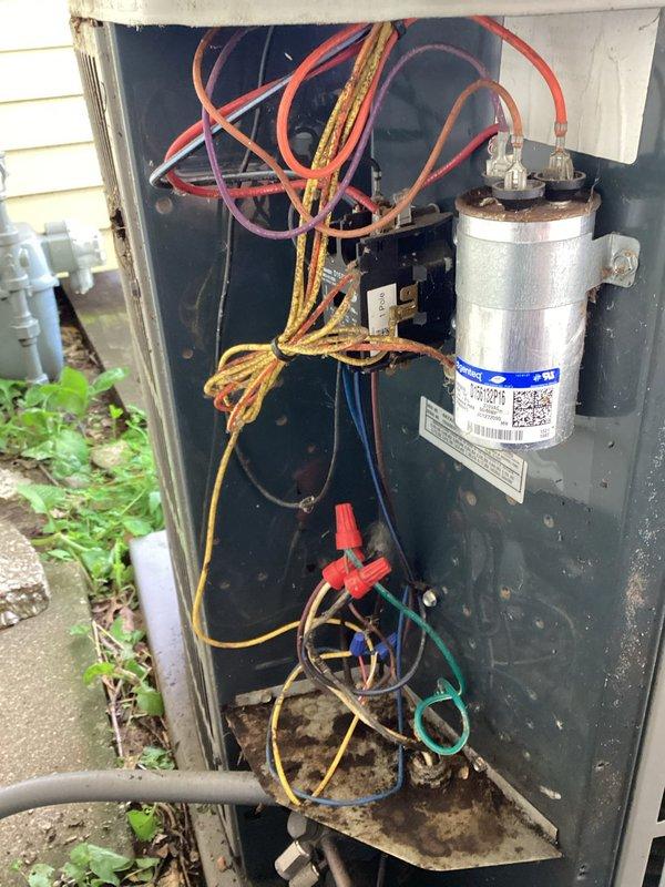 Completed comprehensive preventive maintenance inspection on 9-year-old air conditioning system. Performed standard tune-up procedures including electrical component inspection, capacitor testing, and contactor evaluation. Removed significant accumulation of leaves and organic debris from outdoor unit's electrical compartment and base area to prevent potential airflow restrictions and electrical hazards. Inspected all wire connections, terminals, and hardware for proper operation. Verified capacitor condition and all electrical connections secure despite visible surface corrosion on housing. System operating within normal parameters with no immediate repairs required at this time.