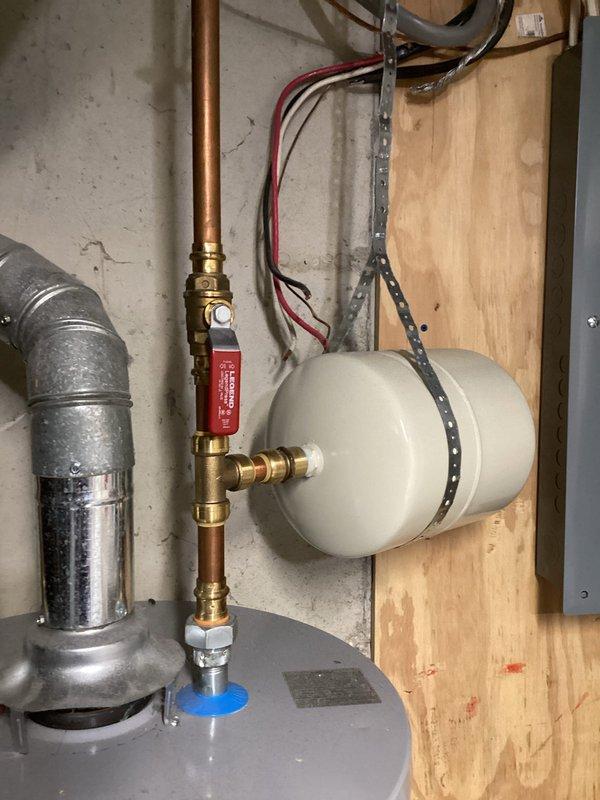 Responded to service call for non-operational 4-year-old tanked water heater with no reported leaking. Upon arrival, performed diagnostic inspection of the unit and associated plumbing connections, including copper piping, brass fittings, pressure relief valve, and expansion tank. Evaluated electrical connections and water heater controls to identify cause of failure. Documented existing installation configuration with photographs showing system components and overall condition of the unit for service records.