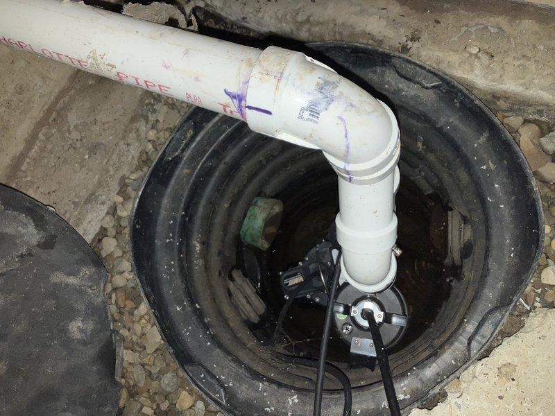 Responded to service call for sump pump in crawlspace that was cycling on briefly then shutting off immediately. Upon arrival, found property without electricity, with pump attempting to operate on backup battery power. Inspected submersible pump installation in black plastic basin with Schedule 40 PVC discharge piping. Diagnosed pump failure due to inadequate power supply from backup battery system unable to sustain pump motor operation under load. Pump would energize momentarily but lacked sufficient voltage to maintain run cycle for effective water removal from basin. Verified electrical connections, tested pump functionality, and confirmed system required either restoration of main electrical service or replacement of backup battery to restore proper sump pump operation for crawlspace groundwater management.