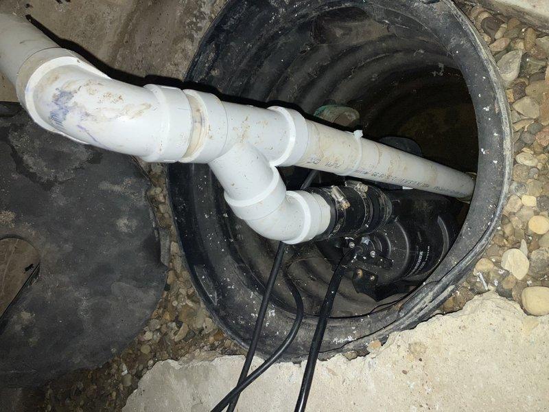Responded to service call for sump pump in crawlspace that was cycling on briefly then shutting off immediately. Upon arrival, found property without electricity, with pump attempting to operate on backup battery power. Inspected submersible pump installation in black plastic basin with Schedule 40 PVC discharge piping. Diagnosed pump failure due to inadequate power supply from backup battery system unable to sustain pump motor operation under load. Pump would energize momentarily but lacked sufficient voltage to maintain run cycle for effective water removal from basin. Verified electrical connections, tested pump functionality, and confirmed system required either restoration of main electrical service or replacement of backup battery to restore proper sump pump operation for crawlspace groundwater management.