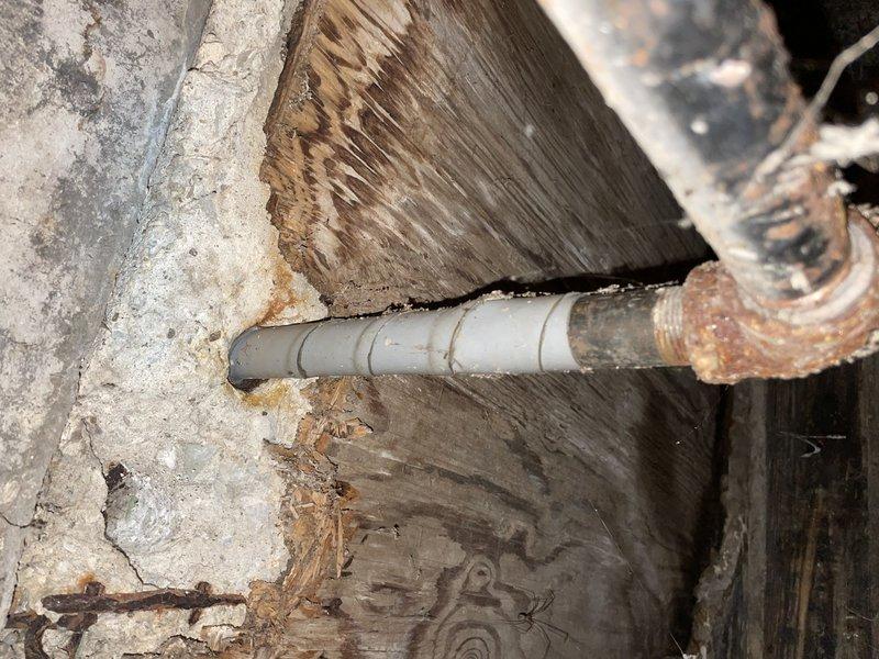 Responded to commercial gas line issue in century-old building that had been affecting a specific area for two weeks. Conducted comprehensive pressure test on central heating system, inspecting aged copper piping with significant oxidation and patina, exterior plumbing assembly with brass fittings, and PVC components including meter housing. Evaluated structural areas including crawl space where PVC lines run through weathered wooden joists and alongside aged concrete surfaces, documenting condition of all gas line connections, joints, and related infrastructure to identify source of ongoing issue.