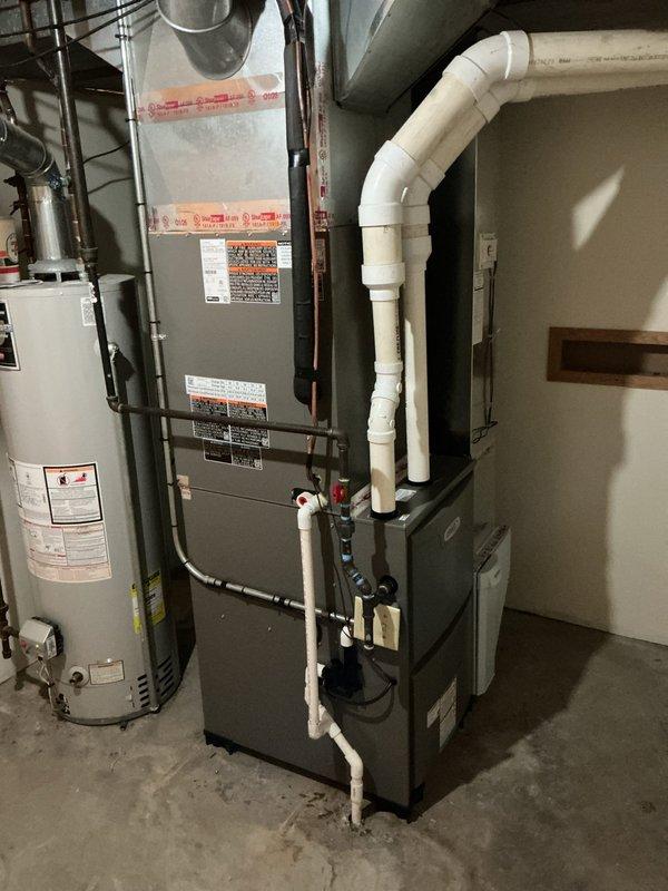 Completed full HVAC system installation including Lennox ML196UH090 high-efficiency modular gas furnace, ML13KC-1036 outdoor condensing unit, CK40CT-30B evaporator coil, and T4 thermostat. Positioned exterior condenser unit on concrete pad against residential brick structure with proper clearances for airflow and service access, connected refrigerant lines and electrical service to manufacturer specifications. Installed furnace and evaporator coil in basement mechanical room with proper venting using PVC piping, integrated gas supply line connections, established condensate drainage, and completed all ductwork modifications for optimal system performance. Verified all electrical connections, tested system operation through complete heating and cooling cycles, confirmed proper refrigerant charge and airflow measurements, and programmed thermostat for efficient climate control.