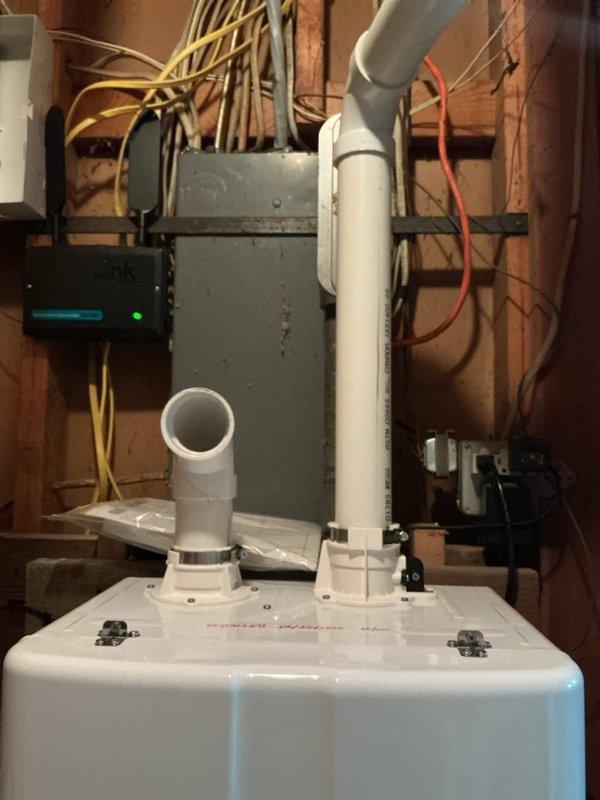 Replaced existing Navien tankless water heater with new NPE-180A2 model in unfinished basement utility area. Obtained necessary permit prior to installation and completed all required plumbing connections including hot and cold water PEX supply lines with ball valve shutoffs, gas line integration via flexible corrugated tubing, and proper venting through white PVC exhaust and intake pipes. Verified electrical connections to control panel, tested unit operation to confirm "OK" status on display, and ensured all connections were secure and leak-free.