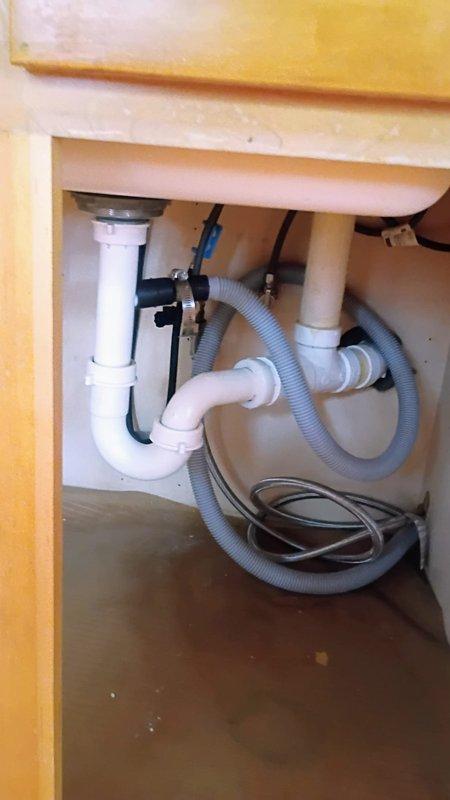 Completed kitchen faucet replacement in 1950s-era home with customer-supplied fixture. Removed existing faucet assembly, installed new brushed stainless steel pull-down model with dual handles and verified all supply line connections beneath sink for proper operation. Tested hot and cold water flow, checked P-trap and drainage system for leaks, and confirmed no issues with existing plumbing infrastructure.