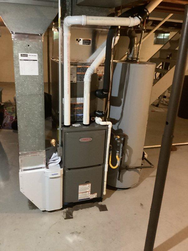 Completed full HVAC system installation in basement mechanical room including ML196UH045 furnace, ML13KC1-024 air handler, and CK40CT-30B condenser unit. Installed and configured all equipment per manufacturer specifications with proper venting using white PVC piping, connected gas supply line with flexible yellow connector, established refrigerant charge to factory specifications, and verified all electrical connections. System tested and operational upon completion with all components functioning within normal parameters.