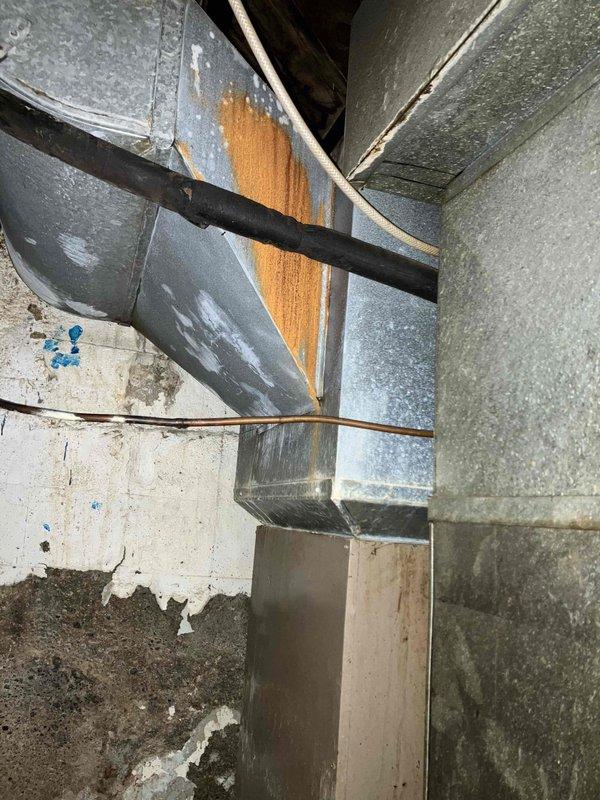 Responded to service call for air conditioning system blowing air but not cooling, with indoor temperature reading 77°F. Performed comprehensive system evaluation and diagnostic assessment of existing HVAC equipment. Inspection revealed aging system with deteriorated refrigerant line penetrations through foundation wall, showing significant corrosion on copper piping and compromised wall integrity at pipe entry points. Observed galvanized ductwork with rust staining and signs of long-term moisture exposure in basement mechanical space. System assessment confirmed loss of cooling capacity with airflow present but no temperature reduction. Provided detailed estimate for complete HVAC system replacement due to age and condition of existing equipment, including new air conditioning unit, associated refrigerant lines, and necessary infrastructure upgrades to address deteriorated components and ensure proper system performance.