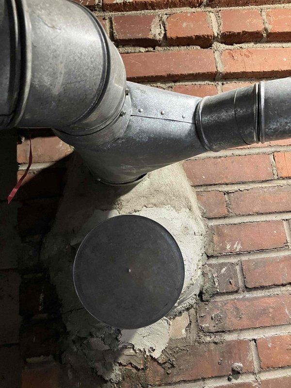 Performed comprehensive assessment of existing HVAC system for complete replacement estimate. Evaluated aging air conditioning unit over 10 years old that was non-operational, affecting entire residence. Inspected exterior condenser unit, electrical disconnect box showing significant weathering and rust deterioration, refrigerant line sets, condensate drainage system, and ductwork installation on exterior brick wall. Documented current system configuration including galvanized metal ductwork, electrical conduit routing, and equipment placement on gravel pad. Provided homeowner with quote options for both full HVAC system replacement and air conditioning unit replacement only.
