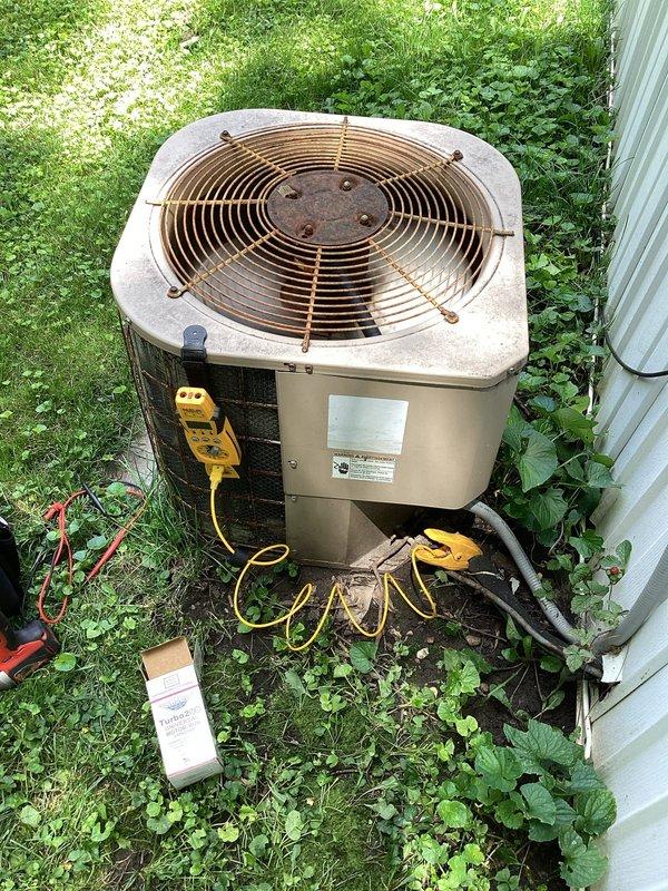 Responded to no cooling call on 10+ year old residential air conditioning system. Upon arrival, performed diagnostic testing on outdoor condenser unit using electrical testing equipment to assess compressor and fan motor operation. Identified system failure preventing cooling operation. Documented equipment condition including weathered fan guard with visible rust and corrosion on aging unit. Verified electrical disconnect and safety labeling present at indoor air handler location. Completed diagnostic evaluation and provided customer with repair recommendations for restoring system functionality.