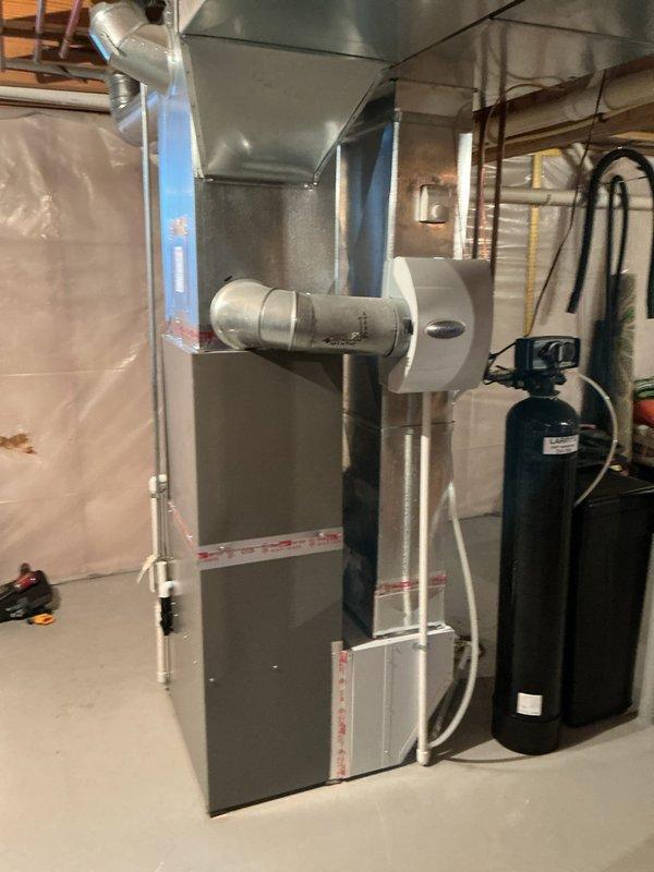 Completed full HVAC system installation in basement mechanical room including Lennox EL297UF070 high-efficiency furnace, EL18KCV-036 air conditioner with CK40CT-30B-71 coil, and S40 smart thermostat. Installed Aprilaire 1610 media air cleaner and 600 humidifier with hot water connection per customer request. All ductwork connections completed, equipment tested and verified operational.