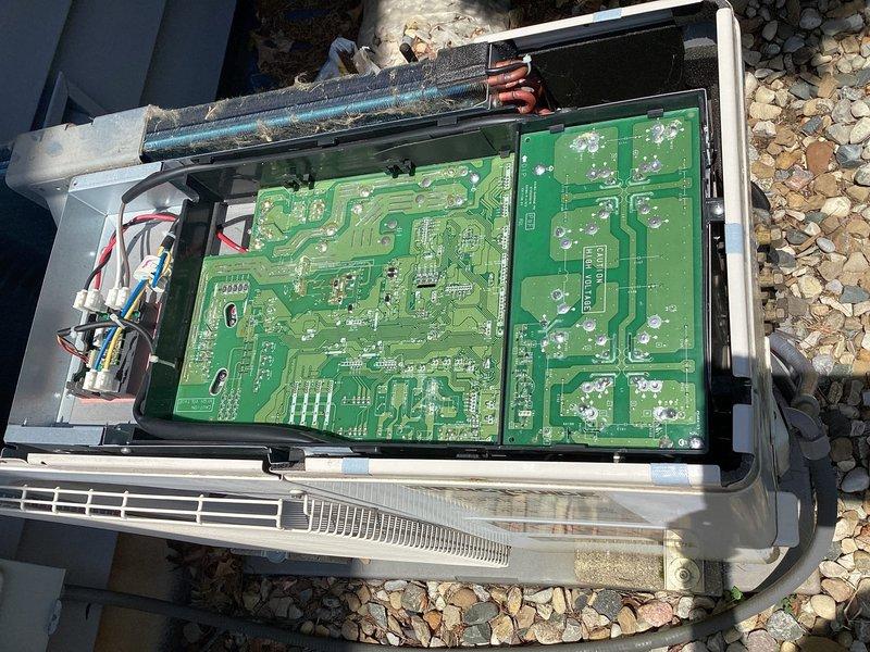 Responded to no-cooling complaint on 5-year-old mini split system. Upon arrival, confirmed units were producing warm air with adequate airflow and no ice buildup present. Performed diagnostic inspection of outdoor unit control boards and electrical components. Removed access panel and examined primary and secondary PCB assemblies for signs of failure, damaged traces, or burnt components. Inspected all wire connections, terminals, and harness routing for loose connections or thermal damage. Evaluated control board circuitry, capacitors, and integrated circuits for proper operation. Checked refrigerant line connections and copper piping at outdoor unit. Documented internal component condition with photos showing circuit board configuration and wiring layout for diagnostic reference.