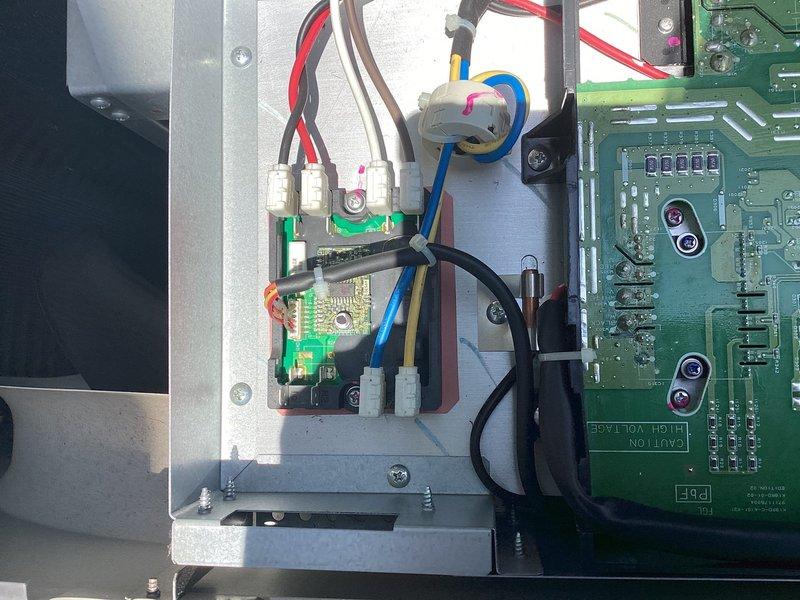 Responded to no-cooling complaint on 5-year-old mini split system. Upon arrival, confirmed units were producing warm air with adequate airflow and no ice buildup present. Performed diagnostic inspection of outdoor unit control boards and electrical components. Removed access panel and examined primary and secondary PCB assemblies for signs of failure, damaged traces, or burnt components. Inspected all wire connections, terminals, and harness routing for loose connections or thermal damage. Evaluated control board circuitry, capacitors, and integrated circuits for proper operation. Checked refrigerant line connections and copper piping at outdoor unit. Documented internal component condition with photos showing circuit board configuration and wiring layout for diagnostic reference.