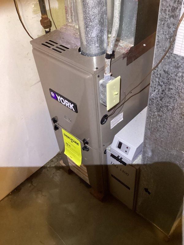 Responded to no cooling complaint on 20-year-old York air conditioning system. Upon arrival, confirmed lack of cooling throughout residence with intermittent outdoor fan operation. Performed diagnostic evaluation of system components including compressor, capacitor, and refrigerant levels. Inspected evaporator coil and air handler for proper airflow and operational status. Noted visible water staining and deterioration on lower section of air handler cabinet indicating previous moisture issues. Checked electrical connections, contactor operation, and thermostat communication. Given the age of the equipment at two decades old, discussed system condition and repair versus replacement options with homeowner. Provided recommendations for addressing cooling failure and outlined available solutions to restore comfort to home.