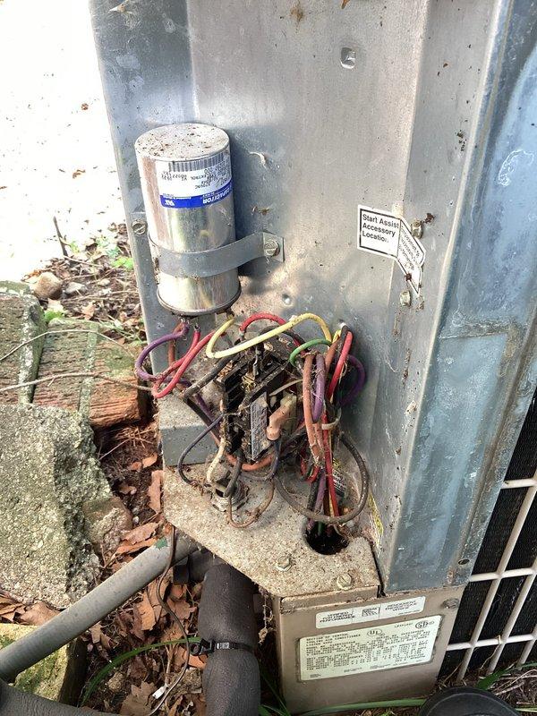 Responded to no cooling complaint following power outage. Found thermostat displaying "cooling is off" with flashing indicator. Reset thermostat to restore cooling mode operation. Inspected 13-year-old York condenser unit located at exterior; observed heavy debris accumulation around base and significant corrosion on contactor assembly. Cleared leaves and organic debris from unit perimeter and interior compartment. Verified capacitor mounting secure and electrical connections intact despite visible oxidation on contactor terminals. Cycled system to confirm proper operation; unit engaged and began cooling cycle successfully. Advised homeowner that heavily corroded contactor and aging system components warrant monitoring and potential replacement to prevent future failure.