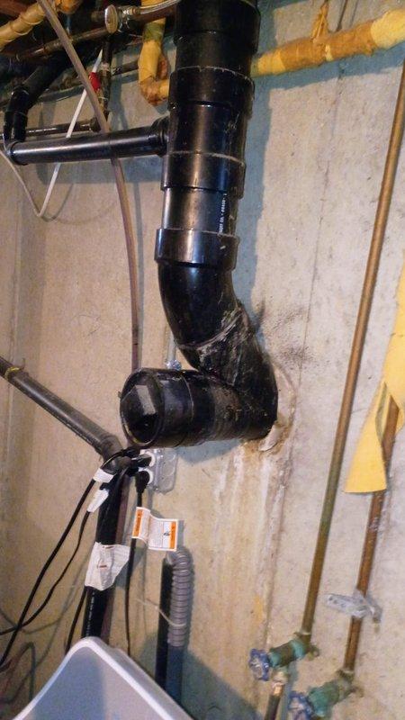 Completed hard piping of AC condensate drain line using black PVC pipe with proper pitch and securing to wall structure. Plugged overflow drain port to prevent future drainage issues. Corrected previous water heater installation to meet code requirements and manufacturer specifications. Investigated and addressed additional basement leak as reported. All plumbing connections tested and verified leak-free upon completion.
