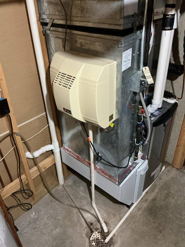 Completed full HVAC system installation including furnace model EL297UH070, air conditioning unit ML17KC2-036, and evaporator coil CK40CT-48B. Installed whole-house humidifier model 1610 integrated into the furnace plenum system with proper ductwork connections. Mounted and programmed digital thermostat S200 for system control. All equipment installed to manufacturer specifications with proper condensate drainage, PVC venting, and electrical connections. System tested and operational upon completion.