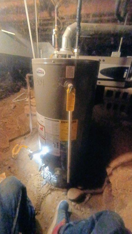 Responded to service call for non-operational 8-year-old residential water heater located in crawlspace. Upon inspection, found unit in deteriorated condition with visible corrosion on tank exterior and aging copper supply lines. Performed diagnostic assessment of gas-fired water heater system, including inspection of burner assembly, thermocouple, gas valve, and venting configuration. Documented equipment condition with photographic evidence showing advanced tank deterioration, compromised insulation jacket, and mineral deposits indicating potential internal tank failure. Verified PVC venting system integrity and proper installation of supply and discharge piping. Provided comprehensive evaluation of system performance and recommended replacement options due to age of unit and extent of deterioration observed.