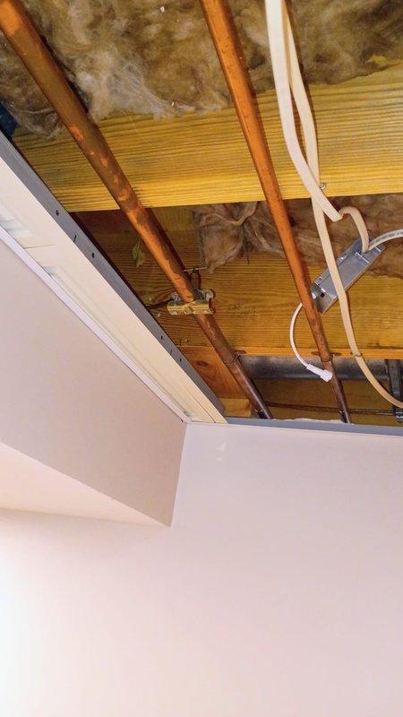 Performed plumbing inspection of existing copper water supply line serving refrigerator. Accessed attic space through ceiling opening to trace water line routing and assess current configuration. Customer requested evaluation and recommendations regarding the water supply line, which currently has no dedicated shut-off valve at the appliance connection point. 

Upon inspection, located copper water supply lines running through attic joists alongside PVC piping and electrical conduit. Documented existing conditions with photographs showing copper line routing, insulation placement, and accessibility for potential modifications. Evaluated feasibility of installing an individual shut-off valve at or near the refrigerator location to provide isolation capability for future appliance replacement or maintenance.

Provided professional recommendations to customer regarding installation of a quarter-turn shut-off valve on the copper supply line, which would allow for convenient water isolation