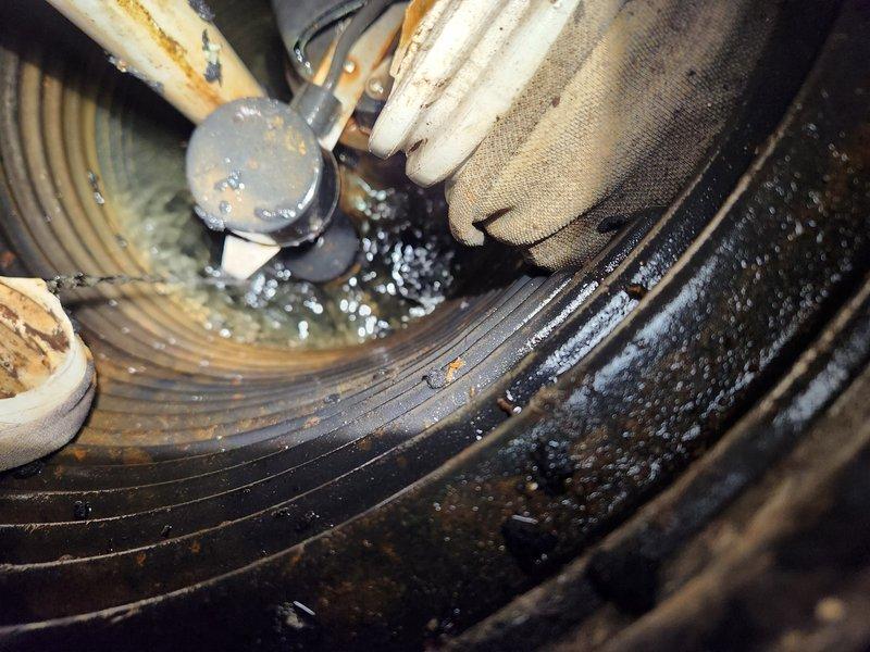Responded to emergency call for groundwater sump pump running continuously without keeping up with water flow. Upon arrival, conducted diagnostic inspection of pump system and surrounding components. Found significant debris accumulation and moisture throughout pump assembly affecting operational efficiency. Inspected blower wheel assembly which showed extensive dust, dirt, and sediment buildup restricting proper function. Noted corrosion on metal piping and connections, with visible rust deterioration on multiple components. Examined electrical connections and wiring for integrity. Documented condensation and water accumulation on corrugated discharge tubing and surrounding ductwork. Assessed insulated piping showing age-related discoloration and wear. Pump motor verified as operational but struggling due to system restrictions and accumulated debris in housing. Photographed conditions for documentation purposes. Provided recommendations for system cleaning, component replacement, and