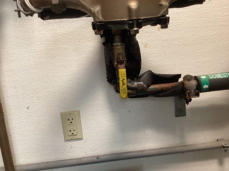 Responded to a water leak in the mechanical room originating from a failing ball valve at the water meter assembly. Upon arrival, found active leak being contained in a bucket with water supply still operational. Inspected the domestic cold water system including backflow preventer assembly and associated piping. Documented the defective ball valve with corrosion present on metal fittings and provided quote for repair work to be scheduled after hours per customer request.