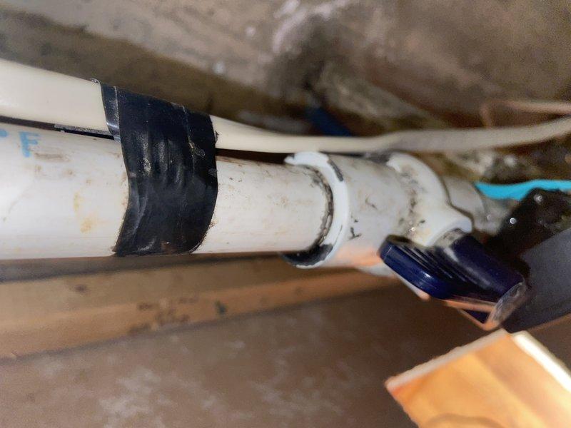 Responded to water leak at main water line entry point into residence. Located active leak on incoming water supply line in crawl space where service enters structure. Installed black rubber repair coupling on white PVC pipe to stop leak and restore water integrity. Secured repair with proper fasteners and verified no additional leaks present at connection points. Water supply restored to normal operation with no standing water remaining in affected area.