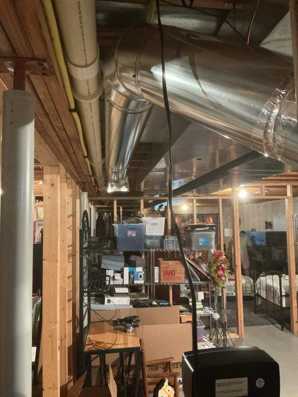 Completed punch list items from previous A/C installation by connecting low voltage wiring to humidifier using spade connectors for 18 AWG wire and installing 8" return duct in basement, relocating intake point to over 10 feet from water heater to meet code compliance requirements. All ductwork properly secured with metal strapping and system tested for proper airflow.