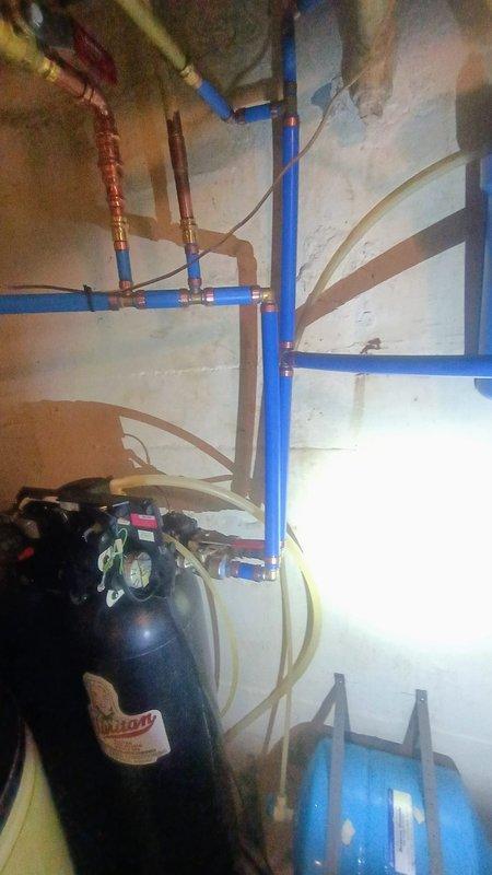 Responded to service call regarding reported water softener leak following previous day's service work. Conducted thorough inspection of utility room plumbing systems including water heater, water softener, filtration system, pressure tank, and associated PEX and copper piping. Examined all connections, fittings, and recently serviced components for signs of active leaking or moisture. Inspected water softener unit, inlet/outlet connections, drain line, and brine tank for potential leak sources. Verified proper operation of expansion tank, pressure vessel, and water treatment equipment. Documented existing plumbing configuration and equipment conditions with photographs for service records.
