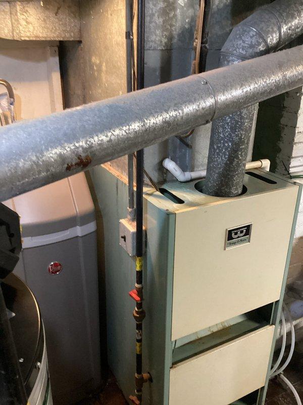 Completed comprehensive AC tune-up on 30+ year old outdoor condensing unit and 77-year old Temp-O-Matic Williamson furnace system. Performed first-time coil cleaning on evaporator coil which had never been serviced, addressing reduced cooling capacity issues. Inspected and cleaned outdoor condenser unit, cleared vegetation and debris from around equipment, and verified system operation to improve cooling performance during high heat conditions.