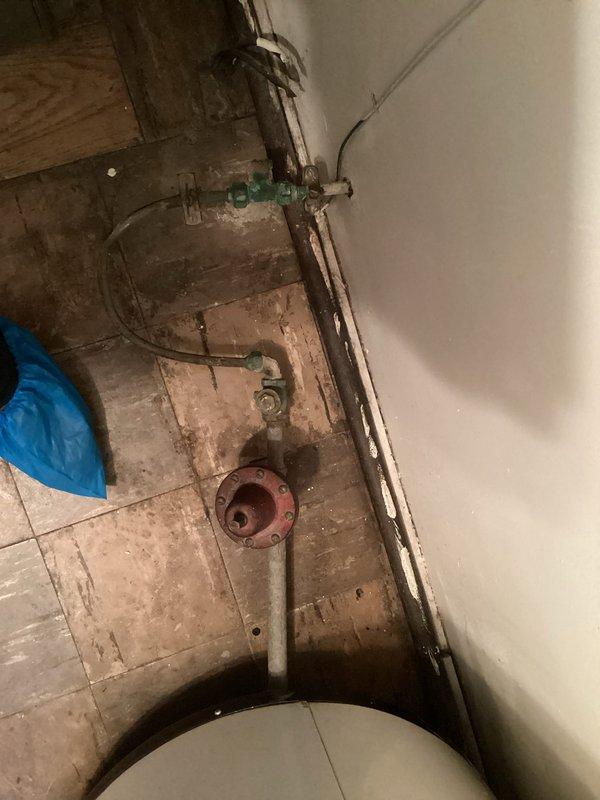 Provided estimate for electric water heater replacement in residential property. Assessed existing plumbing configuration including corroded water supply lines, aged shutoff valves, and drainage system with visible deterioration on surrounding wall surfaces. Service fee waived for this quotation visit.