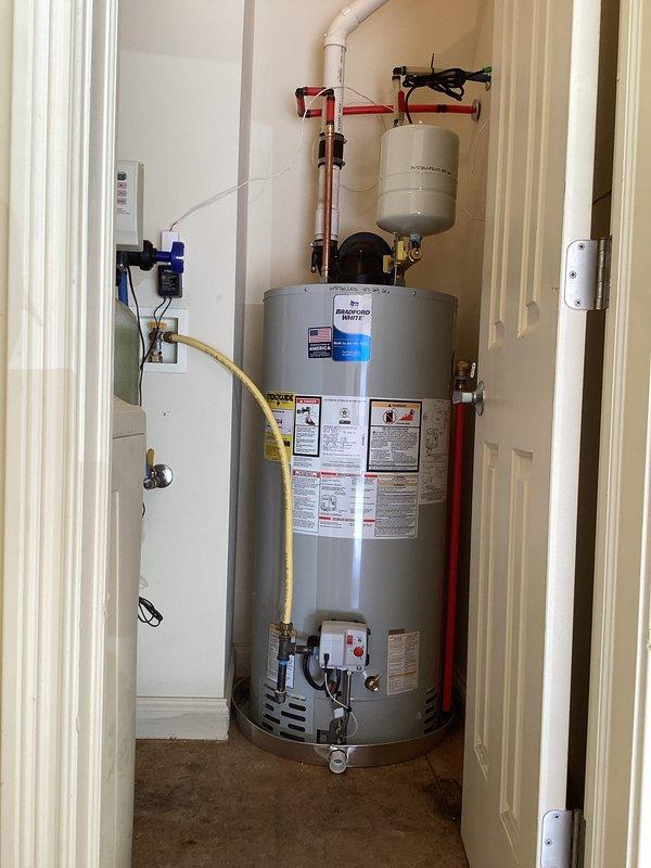 Completed installation of a 50-gallon Bradford White natural gas water heater (Model M-I-50T6FBN) in residential utility closet per customer quote. Unit was properly connected to existing gas line via flexible yellow connector, integrated with expansion tank mounted on overhead bracket, and configured with all required plumbing connections including hot water outlet and cold water inlet. All safety labels, manufacturer specifications, and code-compliant components verified and operational upon completion.