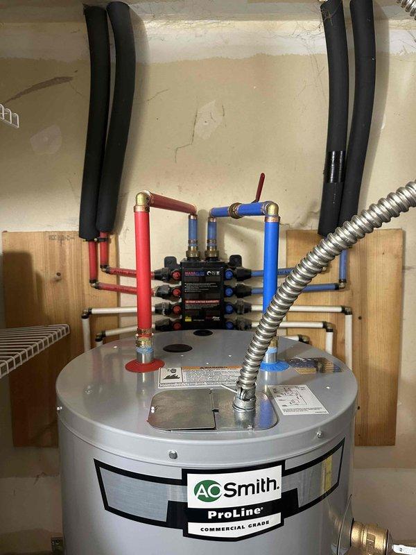 Completed installation of 40-gallon AO Smith ProLine commercial grade water heater at residential property. Installed new unit with professional plumbing manifold system featuring multiple PEX connections, brass fittings, and proper shut-off valves. Applied foam pipe insulation to water lines and ensured all connections were secure and code-compliant.